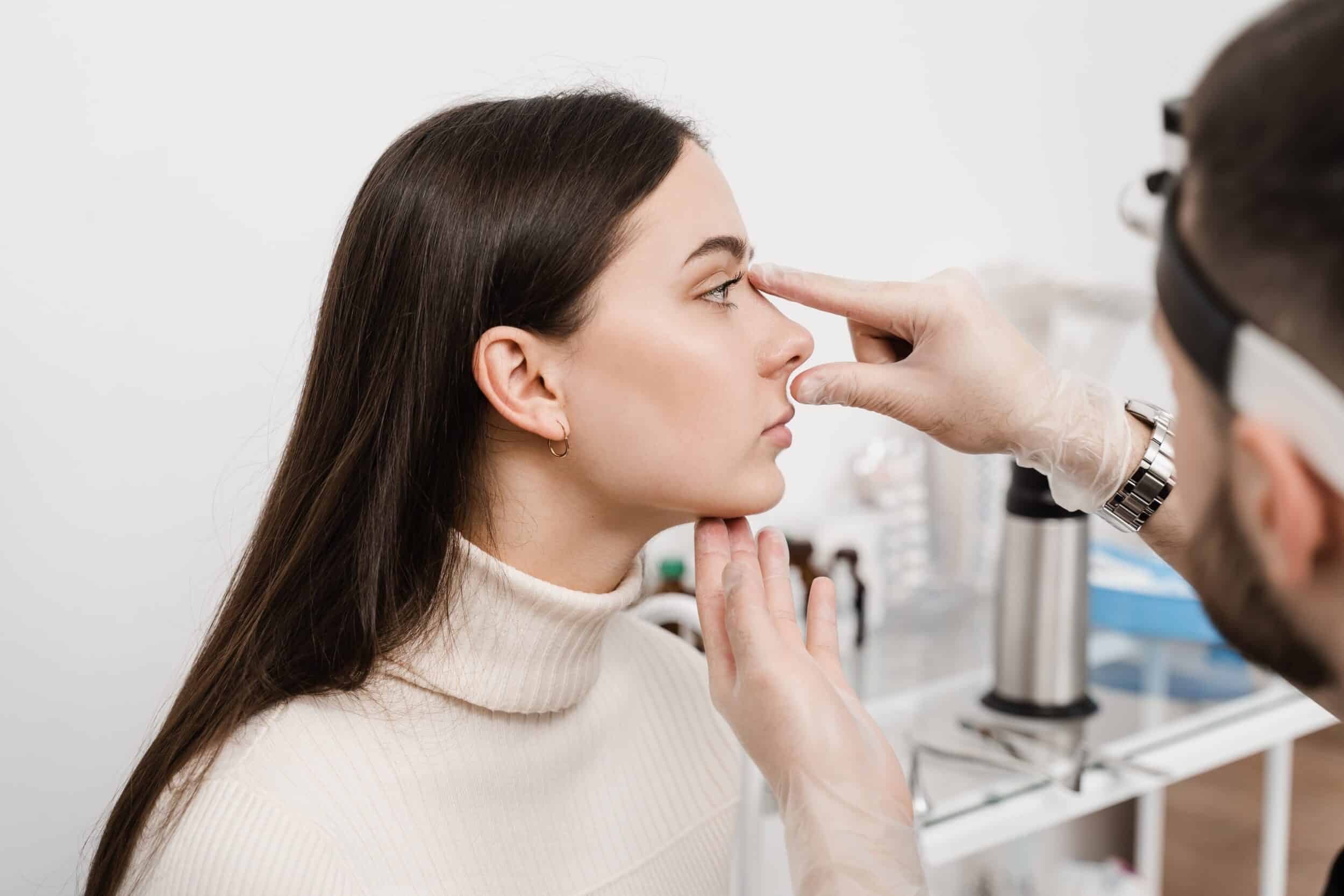 A clinician examining a patient's nose