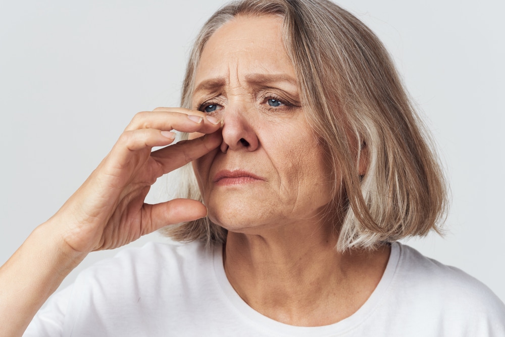 Woman with congestion is irritated by her nose and needs treatment from a sinus specialist.